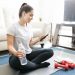 do home workout apps work - young woman sitting on the floor checking her mobile fitness app